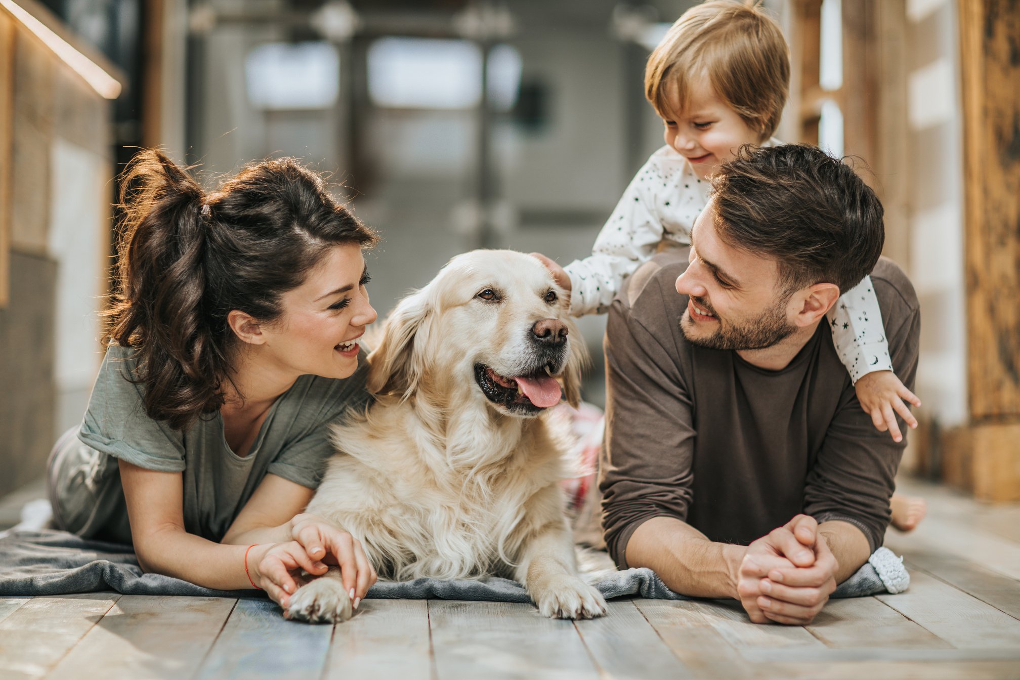 Happy family relaxing with their dog at home.